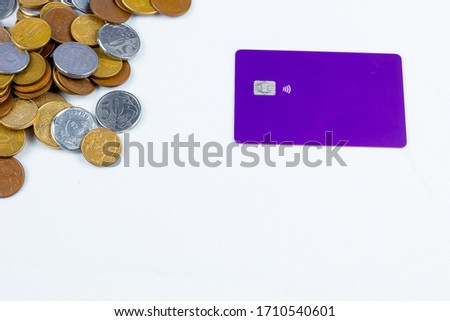several Brazilian coins, a purple credit card