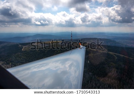 glider wing, blue sky with clouds, lake and forest