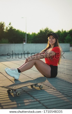 skater girl sitting next to a skate
