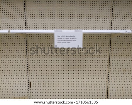 A notice hangs from an empty shelf notifying shoppers that toilet paper rolls are limited to one purchase. This is one month into the Covid 19 pandemic in the US.