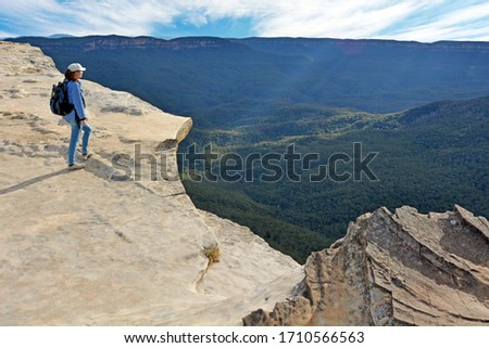 Young adult Australian woman looking at the landscape from Lincoln Rock Lookout at sunset in the Blue Mountains National Park in New South Wales, Australia. Real people. Copy space