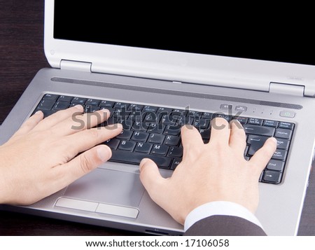 Hands typing on a laptop computer keyboard