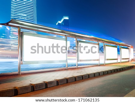 Blank billboard on bus stop at night 