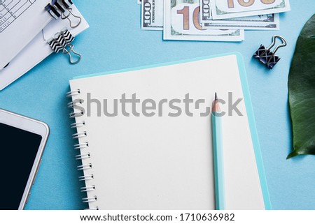 Notebook with place for text and pencil on a blue desktop. Business or tax concept 