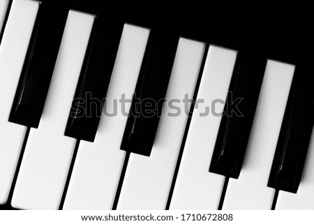 Black and white piano keys close up.