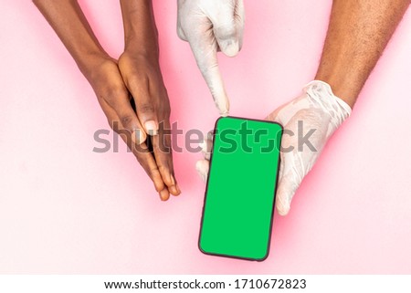 doctor showing a patient something on his phone concept, wearing surgical gloves, hands only