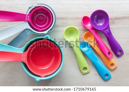 Set of colorful measuring cups and measuring spoons use in cooking lay on wood tabletop in top view. Royalty-Free Stock Photo #1710679165