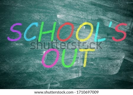 Text SCHOOL'S OUT written on chalkboard, top view