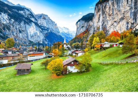 Amazing autumn landscape of touristic alpine village Lauterbrunnen with famous church and Staubbach waterfall. Location: Lauterbrunnen village, Berner Oberland, Switzerland, Europe. Royalty-Free Stock Photo #1710706735
