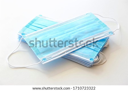 Coronavirus protection. Blue antiviral medical face masks. Surgical protective masks with ear loops on white background.                    Royalty-Free Stock Photo #1710723322