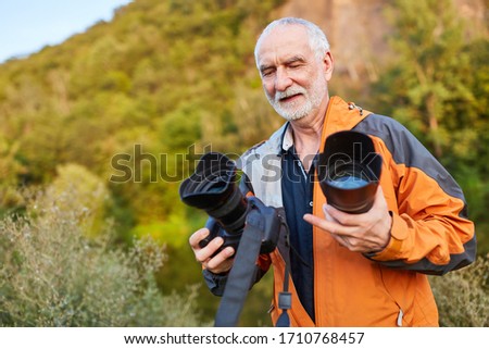 Professional senior photographer with different lenses in nature
