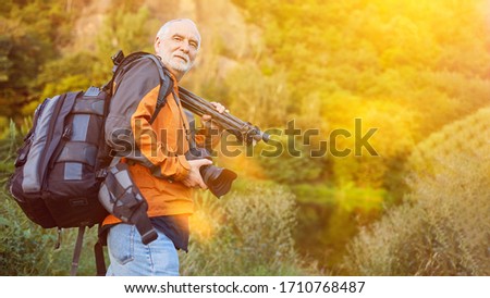 Nature photographer with camera and equipment in backpack in landscape photography