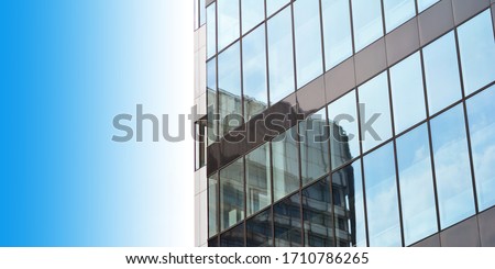 a modern architecture building glass facade with a reflection of another building and with a room for your topic Royalty-Free Stock Photo #1710786265