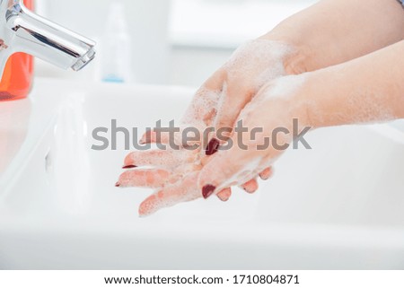 Woman use soap and washing hands under the water tap. Hygiene concept hand detail. Corona virus protection