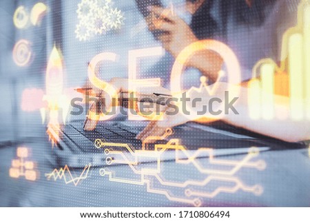 Double exposure of woman hands working on computer and seo hologram drawing. internet search concept.
