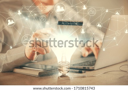 Double exposure of man hands holding a credit card and bulb drawing. Idea E-commerce concept.