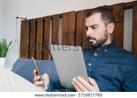 Man with digital tablet and smartphone. Work from home concept.