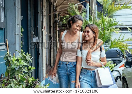 Two pretty smiling girls enjoy shopping outdoor stock photo