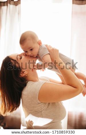 Happy cheerful family. Mother and baby kissing, laughing and hugging