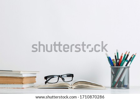 Books and school supplies on white background. The concept of a postcard for teacher's day. Copy space.
