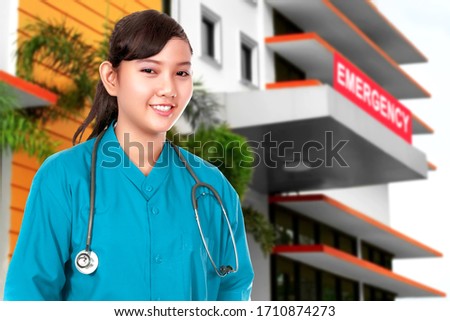 Asian Doctor woman with stethoscope standing in front of the emergency room in the hospital
