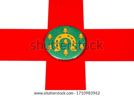 A badge portraying the flag of the English county of Rutland pictured over the England flag.