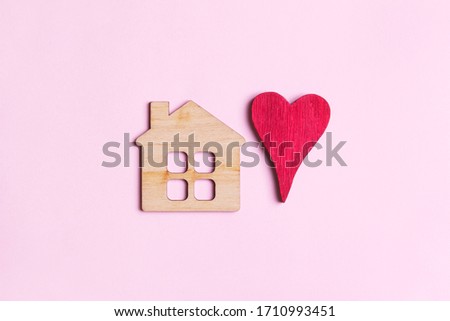 sweet home concept, mini wooden house symbol and red heart on wooden background, top view, flat lay