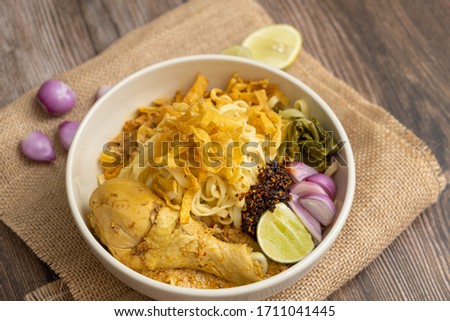 Khao Soi Chicken, Northern Thai Food on the wooden table - Stock photo