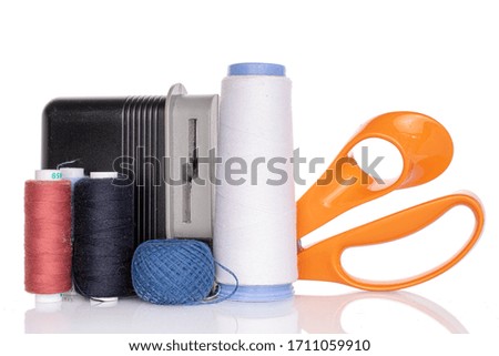 Thread spools with scissors and sharpener isolated on white
