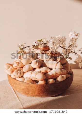 Bagels with jam in a wooden plate with a flowering branch. Rustic Food photo