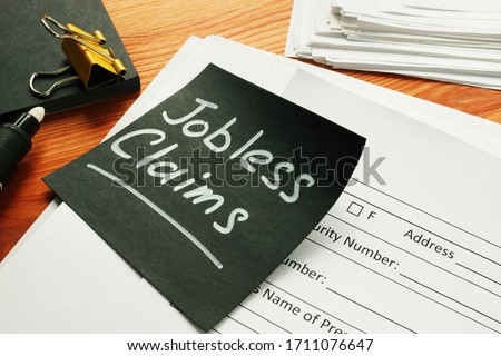 Jobless claims memo stick and pile of documents. Royalty-Free Stock Photo #1711076647