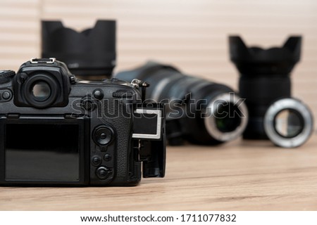 memory card, digital camera, dslr and body black camera placed on a wooden table