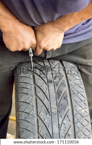 The picture shows the hand mechanics are repairing a leaky tire and a sealing tires