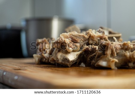 Cooked small pieces of veal bone with meat base for soup concentrate set of wood board in the kitchen 2020