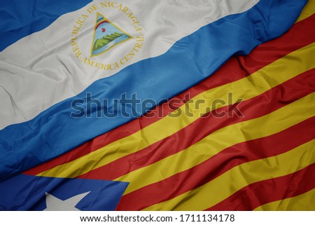 waving colorful flag of catalonia and national flag of nicaragua. macro