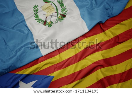 waving colorful flag of catalonia and national flag of guatemala. macro