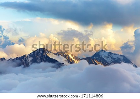 alpine landscape with peaks covered by snow and clouds Royalty-Free Stock Photo #171114806
