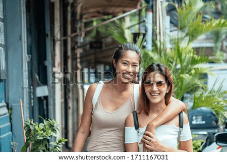 Portrait of two happy friends laughing and posing looking at you in the street stock photo