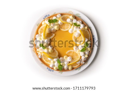 Lemon meringue pie decorated with mint leafs - Top view and isolated on white background