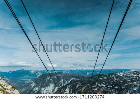 View from funicular to cableway and the Alps snowy mountains on the horizon. Beautiful panoramic picture contains blue sky and copy space. 