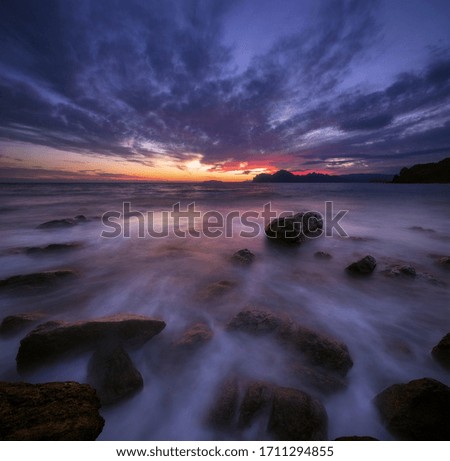 Seascape with a very beautiful picturesque sky at sunset and mountains