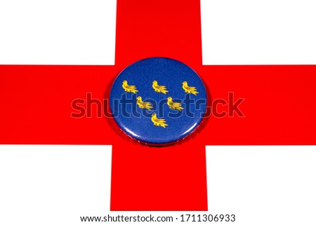 A badge portraying the flag of the English county of Sussex pictured over the England flag.