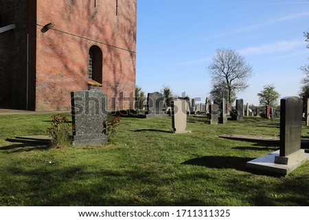 Old and characteristic Dutch cemetery near a church. photo was taken on a sunny spring day.