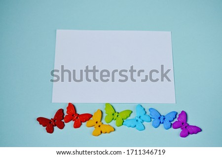 rainbow-colored butterflies with a frame for inscription against the background of mint color