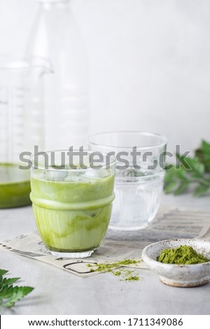 matcha tea with ice and milk in a glass on a grey background Royalty-Free Stock Photo #1711349086