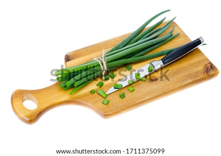 Wooden kitchen cutting board for slicing fresh green onions. Studio Photo