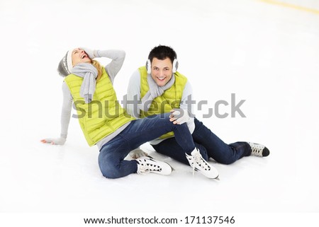 A picture of a young couple ice-skating on a rink