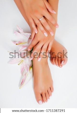manicure pedicure with flower lily closeup isolated on white perfect shape hands spa salon Royalty-Free Stock Photo #1711387291