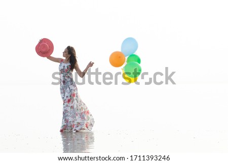 motivation or hope concept, follow your dream and inspiration, girl with balloons at sunset with sea 
