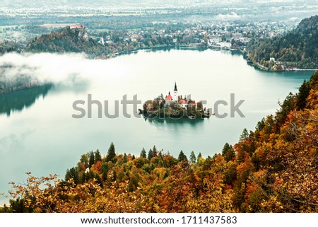 Aerial view of church of Assumption in Lake Bled, Slovenia in the aurumn with colorful trees